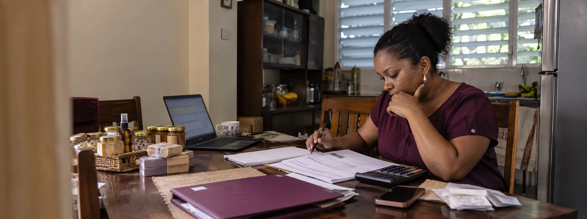 A Caribbean business owner organising her business records and planning her next move.